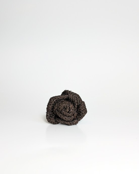 A small dark brown textured fabric rose lapel accessory, centered on a clean white background.