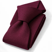 Folded burgundy tie on a white background