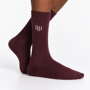 Maroon socks with a logo on the leg against a white background