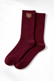Pair of burgundy socks with a logo on a white background