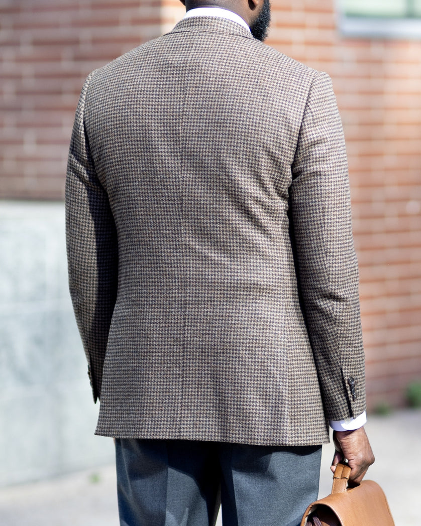 Man wearing a houndstooth sport coat with a blurred background