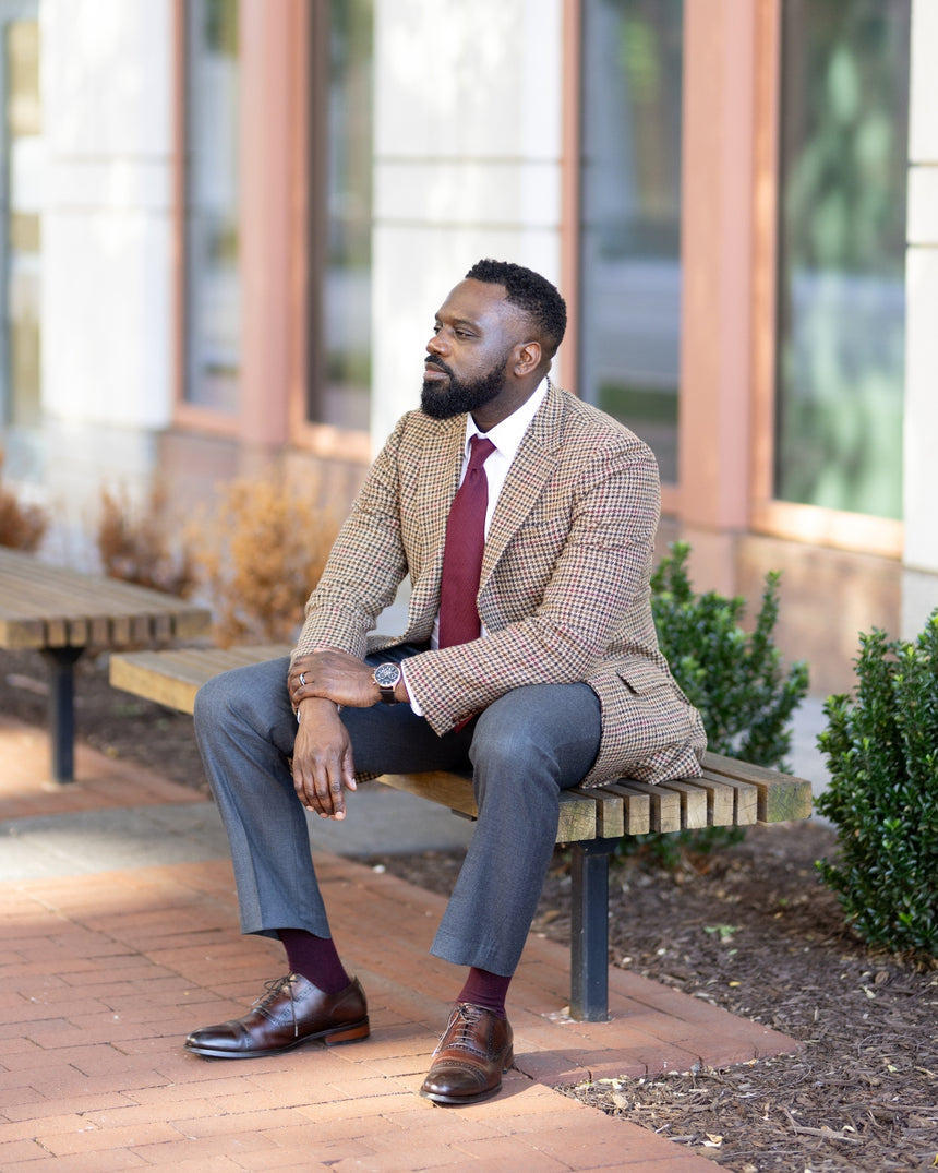 Man in a suit sitting on a bench outdoors