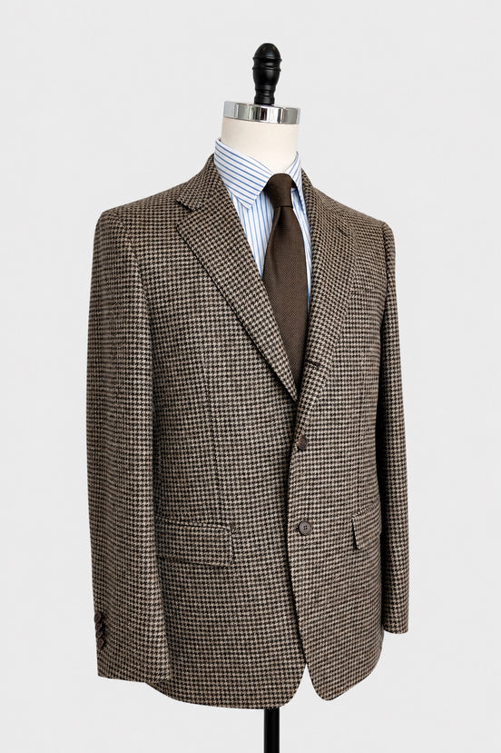 A brown and beige houndstooth blazer displayed on a mannequin torso, styled with a blue and white striped shirt and a brown tie, against a light gray background.