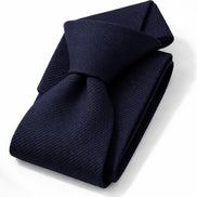 Folded navy blue tie on a white background