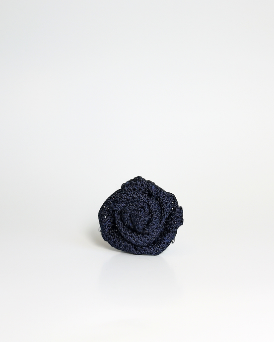 A small navy textured fabric rose lapel accessory, centered on a clean white background.