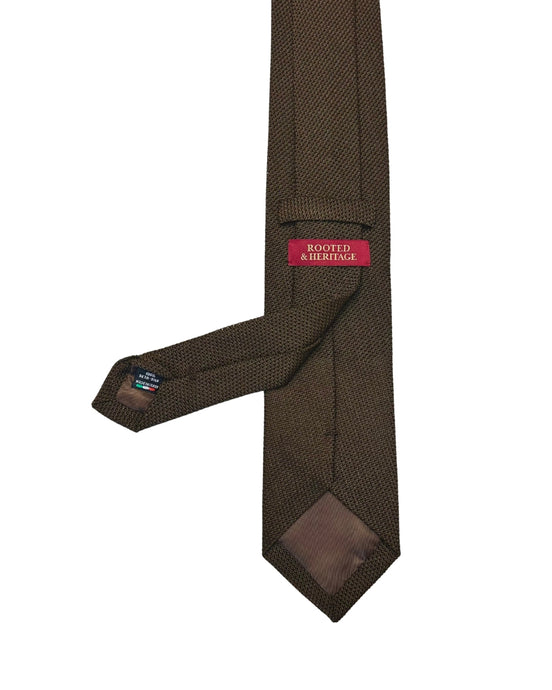 Brown textured tie with a Rooted & heritage label on a white background