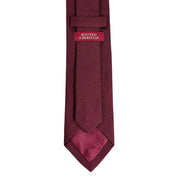 Maroon tie with a brand label on a white background