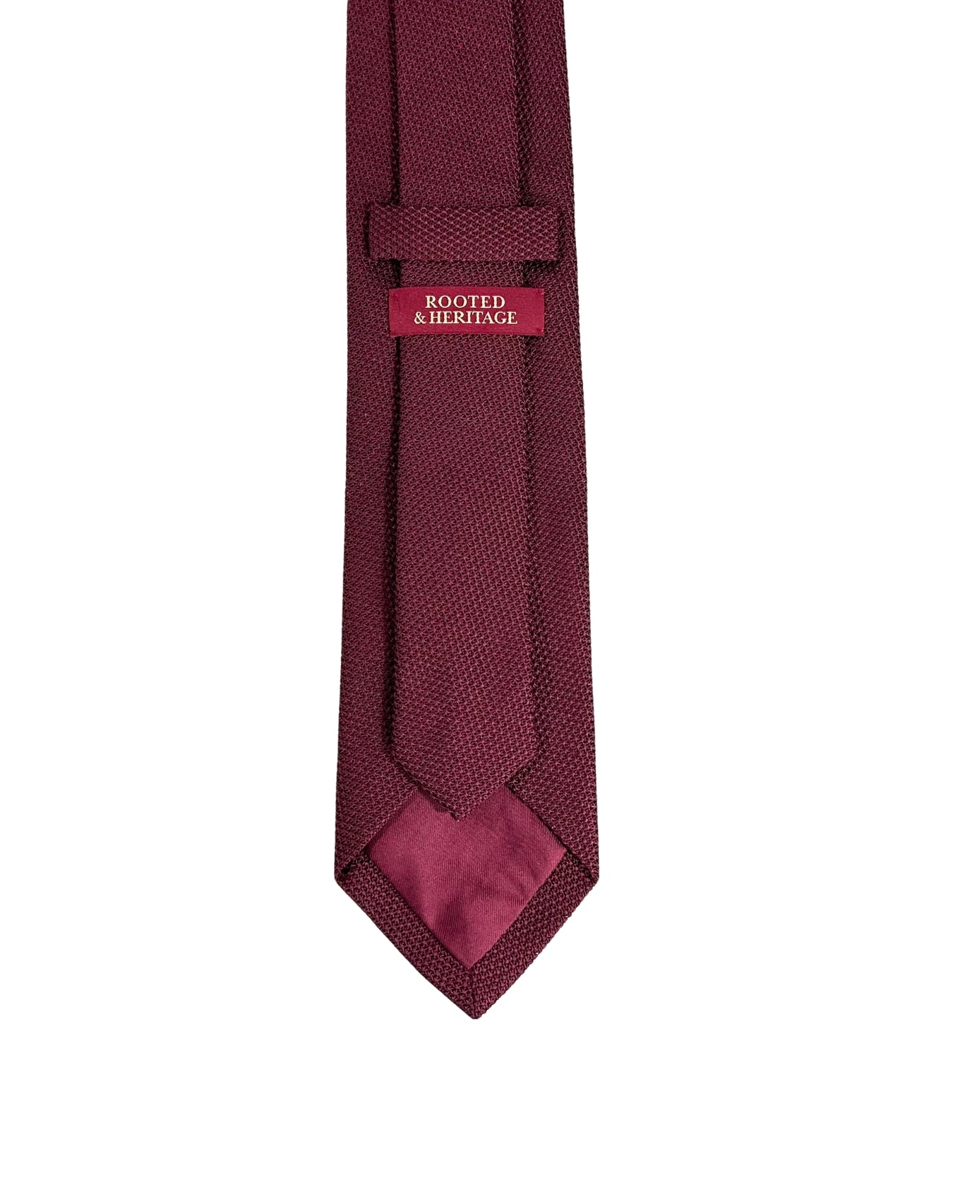Maroon tie with a brand label on a white background
